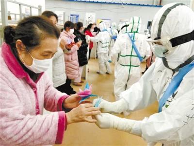 武漢沌口方艙醫院 甘肅醫療隊員與女性患者共迎“女神節”送上千紙鶴 同跳健康操