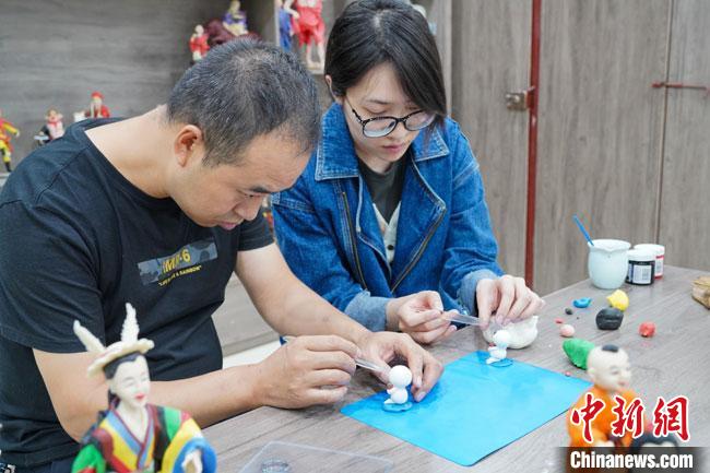 <a target='_blank'  data-cke-saved- >中新社</a>記者(右)現(xiàn)場(chǎng)體驗(yàn)面塑制作過程?！￡悹?zhēng)強(qiáng) 攝