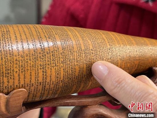 圖為長約二十公分的長條葫蘆雕刻佛教經文作品?！堟?攝
