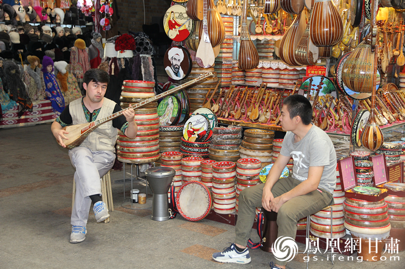 烏魯木齊二道橋巴扎內，店主正在向客人展示樂器。楊文遠 攝