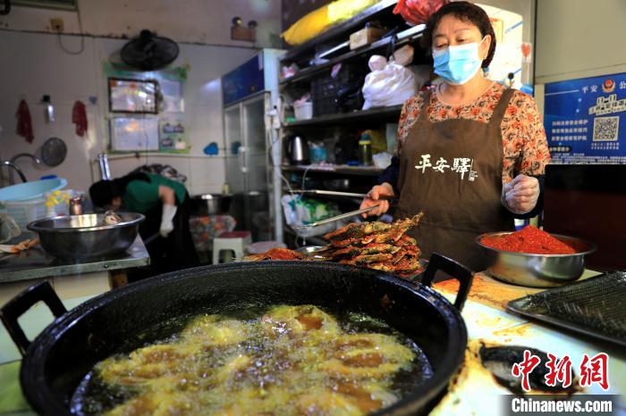 圖為平安驛·河湟民俗文化體驗地內的商戶炸干板魚。　薛蒂 攝