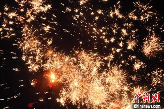 灼熱的鐵水在空中迸散。在空中形成“鐵花火雨”的景象，似天女散花，似群星漫天，如夢如幻，美不勝收。侯奇志 攝</p>
<p>